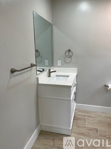 A white bathroom vanity with a mirror above it.