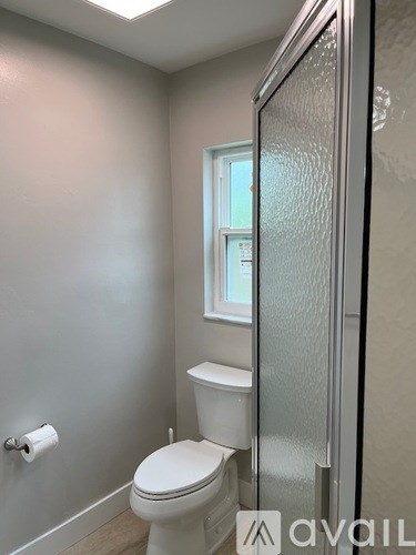 A white toilet in a bathroom with a glass shower door.