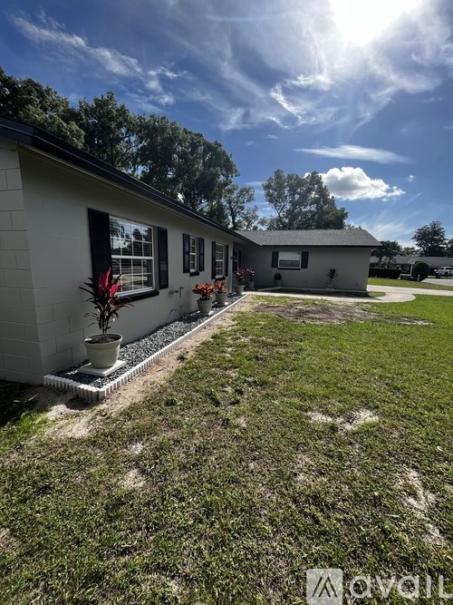 A house with a well-kept lawn and a clear sky above.