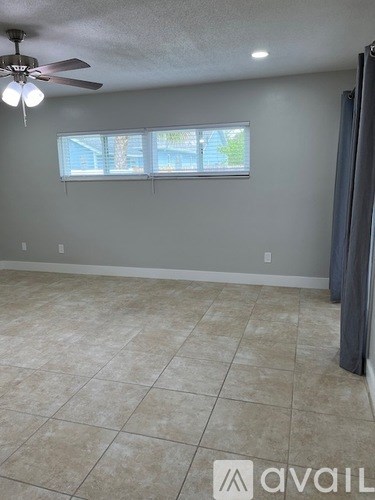 A room with a ceiling fan and tiled floor.