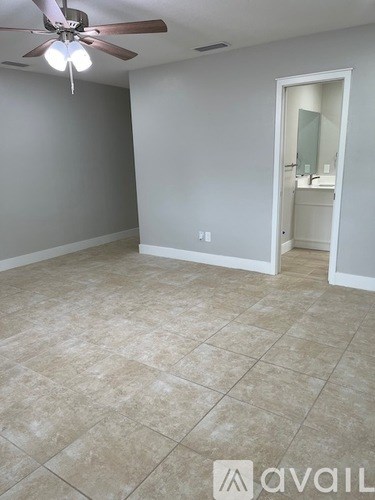 A room with a ceiling fan and tile flooring.