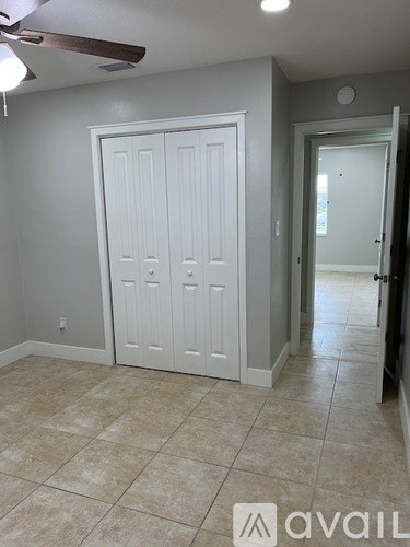 A room with a white door and a fan on the ceiling.