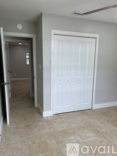 A room with a white door and a tiled floor.