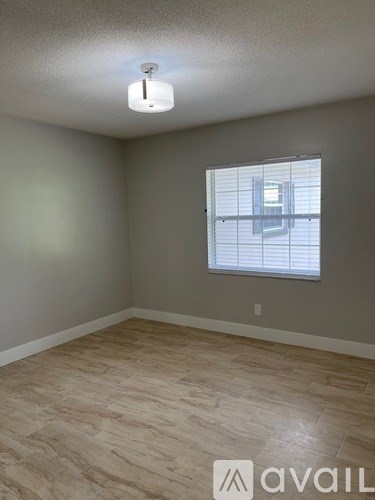 A room with a window and a light on the ceiling.