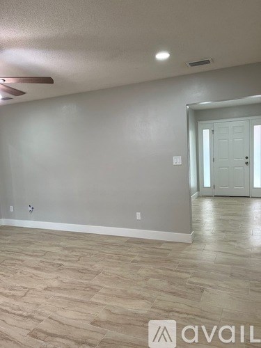 A room with a light grey wall and a wooden floor.
