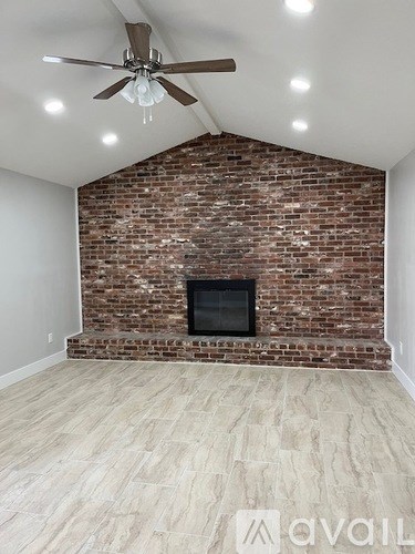 A room with a brick wall and a fireplace.