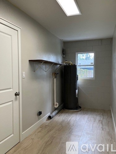 A room with a white door and a black water heater.