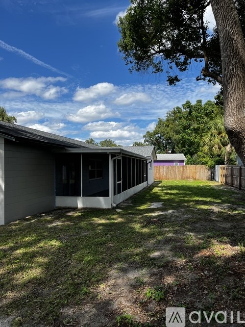 A house with a backyard and a tree in front.