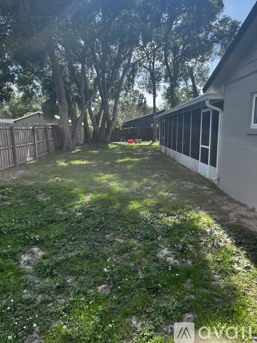 A backyard with a fence and trees.