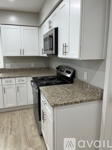 A kitchen with granite countertops and white cabinets.