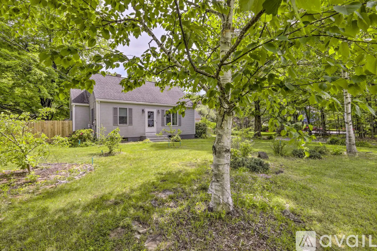 A house is surrounded by greenery and trees.
