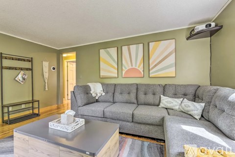 A living room with a grey couch and a coffee table.