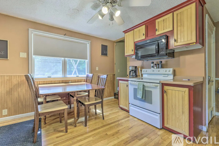 A kitchen with wooden cabinets and a white stove top oven.