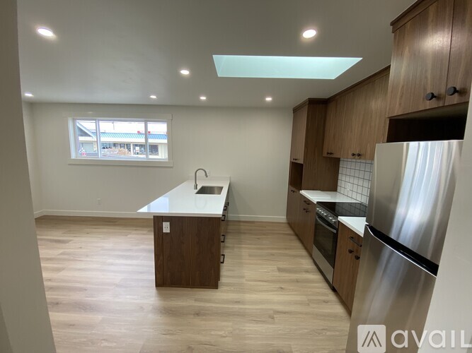 A kitchen with wooden cabinets and a stainless steel refrigerator.