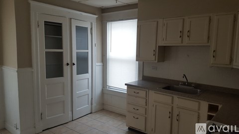 A kitchen with white cabinets and a sink.