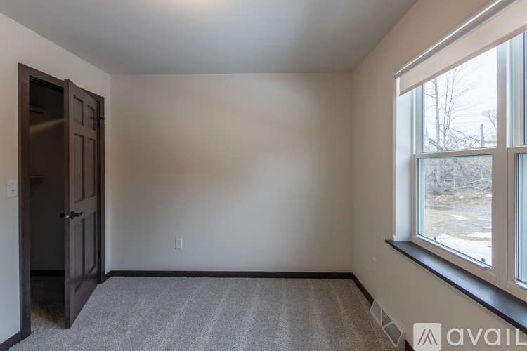 A spacious garage with a metal gate and wooden walls under construction.