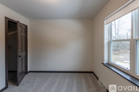 A spacious garage with a metal gate and wooden walls under construction.