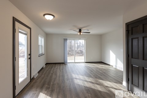 A spacious room with a ceiling fan and sliding glass doors.