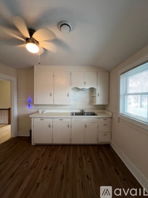 A kitchen with white cabinets and a ceiling fan.