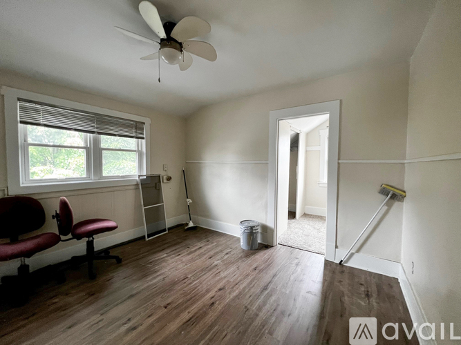 A room with a ceiling fan and a window with blinds.