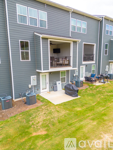 A grey apartment building with a balcony and a patio area.