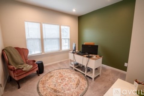 A living room with a red chair and a television.