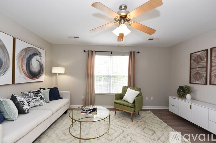 A living room with a white couch, a green chair, and a coffee table.