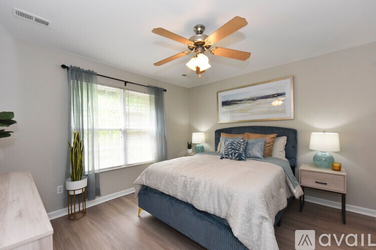A bedroom with a bed, nightstand, and a ceiling fan.
