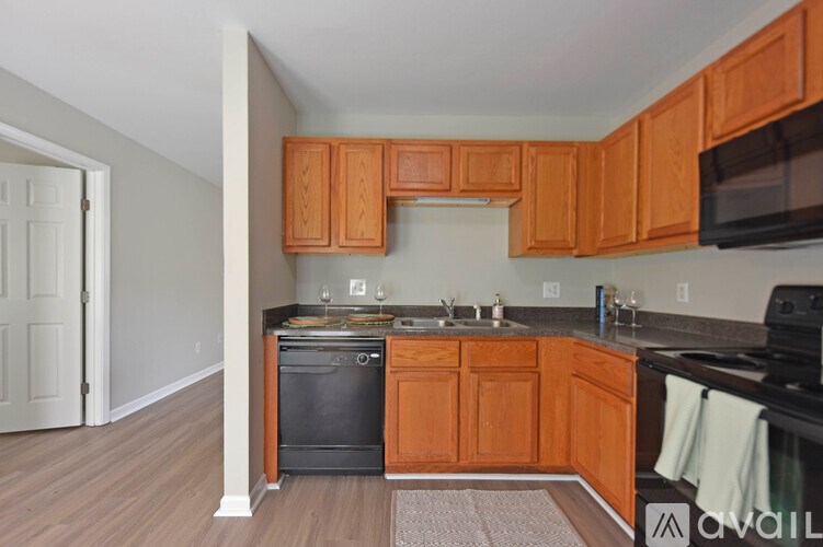 A kitchen with wooden cabinets and a black oven.