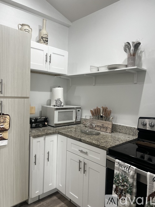 A kitchen with white cabinets and a black stove top.