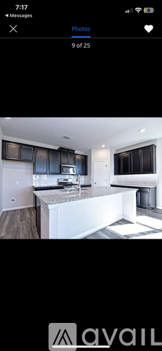 A modern kitchen with black cabinets and a white island.
