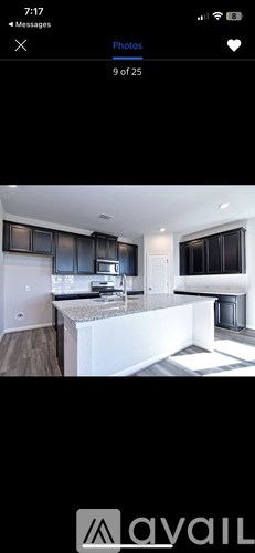 A modern kitchen with black cabinets and a white island.