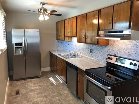 A kitchen with a stove top oven and a refrigerator.