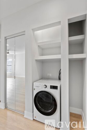 A washing machine is sitting in a small laundry room.