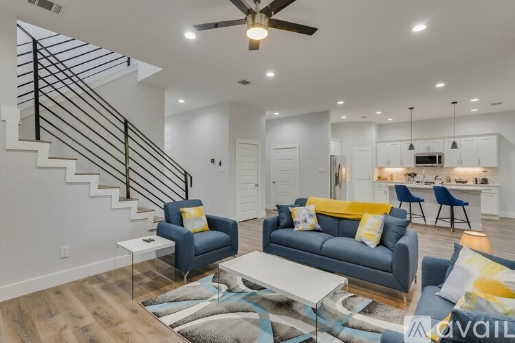 A living room with a blue couch and a white coffee table.