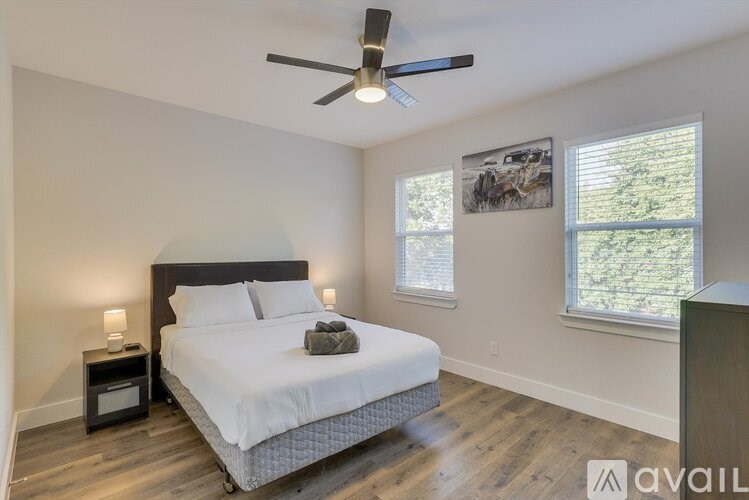 A bedroom with a bed, nightstand, and a ceiling fan.