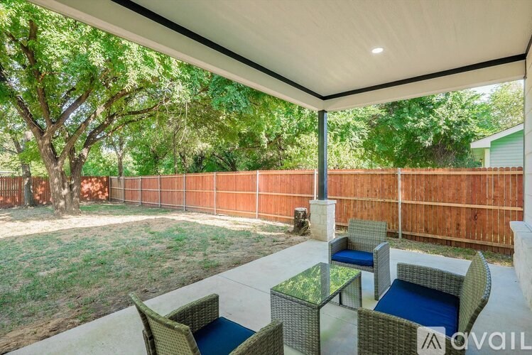 A patio with a table and chairs under a roof.