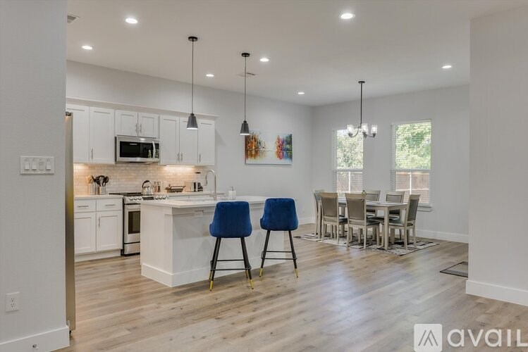 A kitchen with a dining table and chairs.