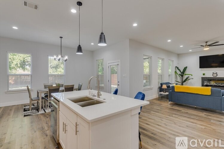 A modern kitchen with a large island and pendant lights.