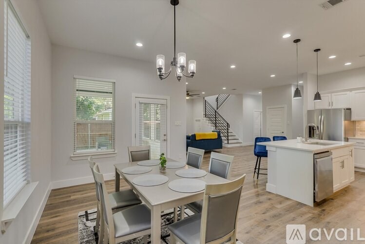 A modern dining room with a white table and chairs.