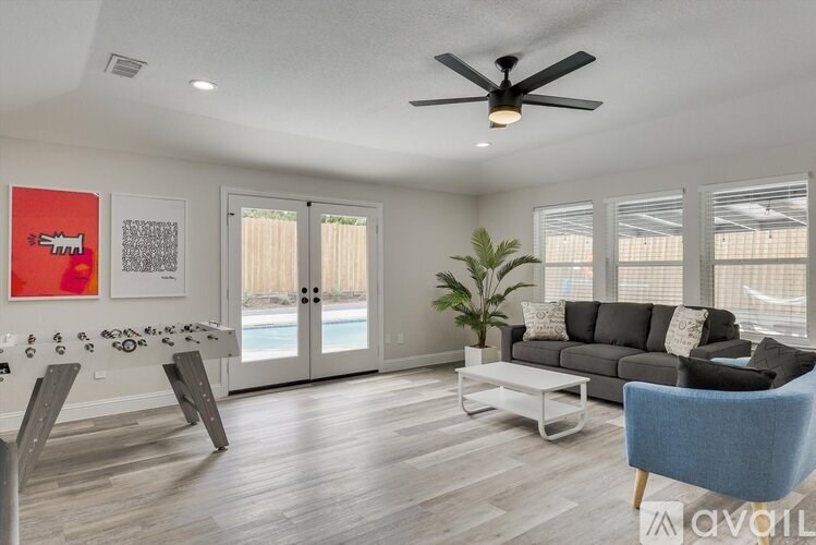 A living room with a grey couch, a blue chair, and a white coffee table.