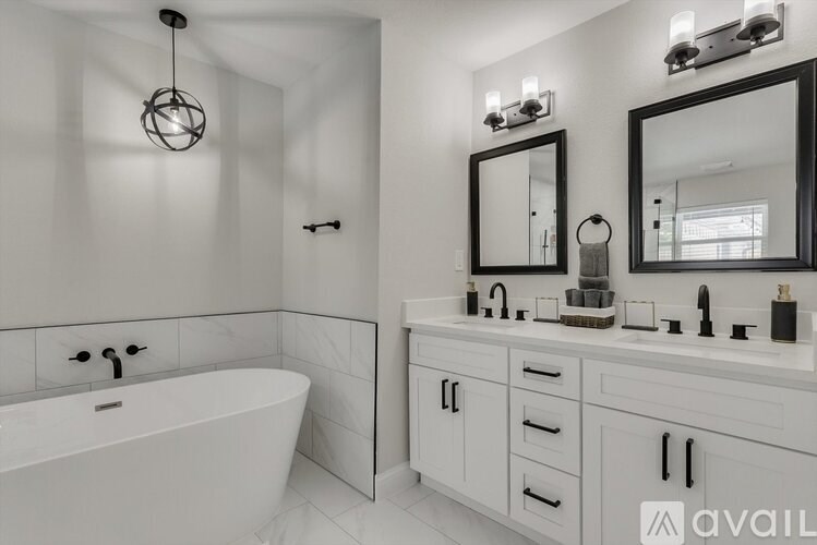 A bathroom with a white tub and sink vanity.