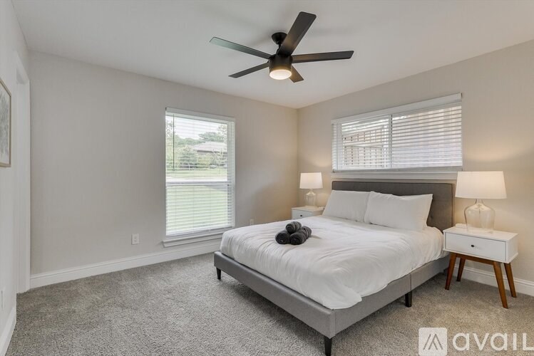 A bedroom with a bed, nightstand, and window.