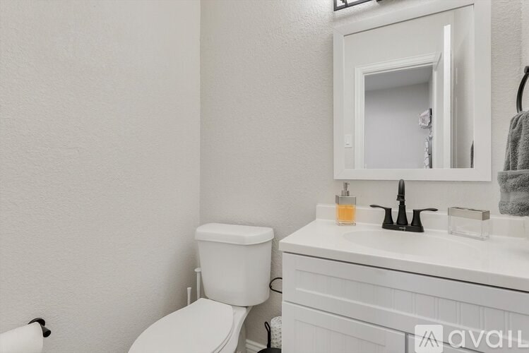 A white toilet sits next to a white sink in a bathroom.