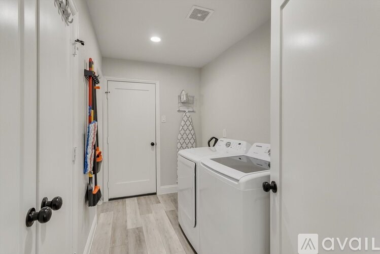 A white laundry room with a washer and dryer.