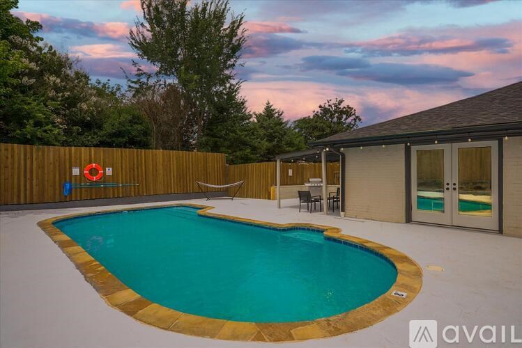 A pool surrounded by a wooden fence with a lifebuoy hanging on it.