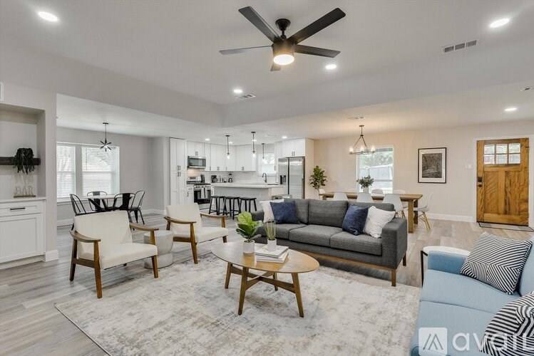 A living room with a grey couch, a coffee table, and a ceiling fan.