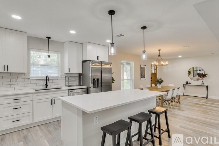 A modern kitchen with white cabinets and a large island.
