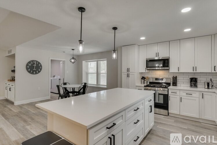 A modern kitchen with white cabinets and a large island.