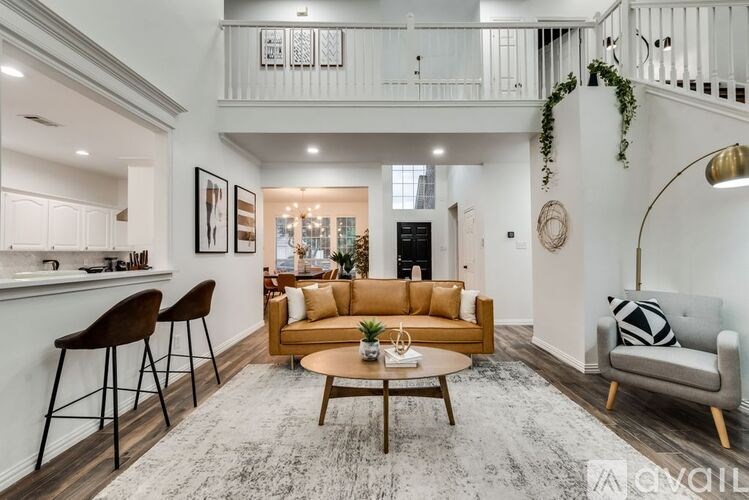 A living room with a brown sofa and a grey armchair.